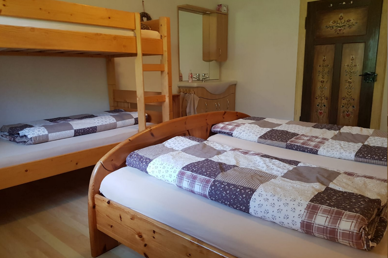 4-Bettzimmer im Obergeschoss mit Stockbett, Doppelbett und Waschtisch – Gästehaus Käskucha im Allgäu, ideal für große Gruppen