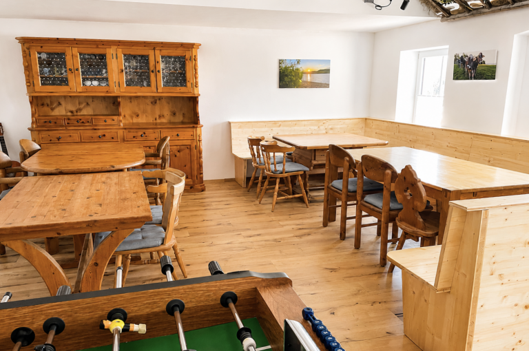 Großer Aufenthaltsraum im Gästehaus Alte Käskucha im Allgäu mit Kicker, Sitzbereichen und Holzinterieur nahe Rottachsee