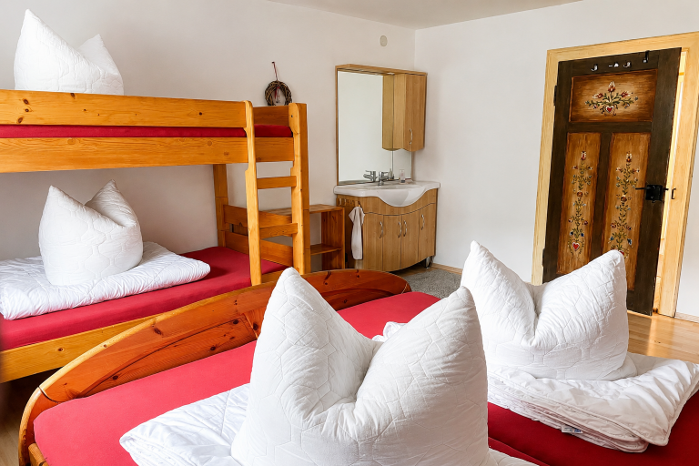 4-Bettzimmer im Obergeschoss mit Stockbett, Doppelbett und Waschtisch – Gästehaus Käskucha im Allgäu, ideal für große Gruppen